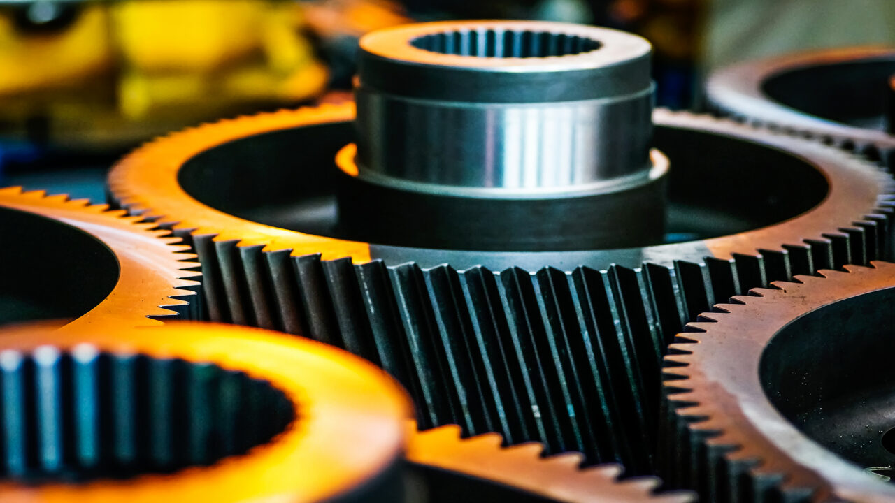Detalhe de engrenagens industriais metálicas em close, representando precisão e desempenho mecânico.
